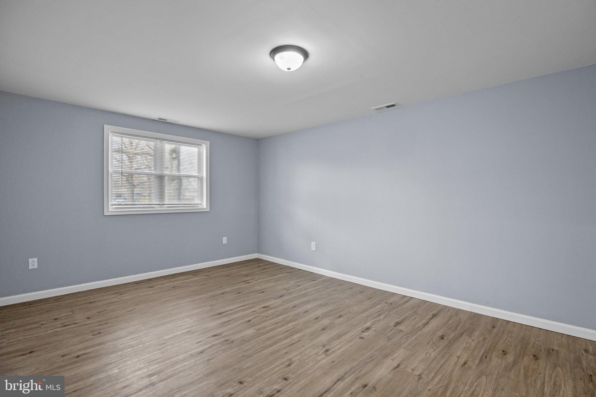 26 Oaktree Drive Levittown, PA 19055 - Photo 11 of 19 a view of an empty room with wooden floor and a window