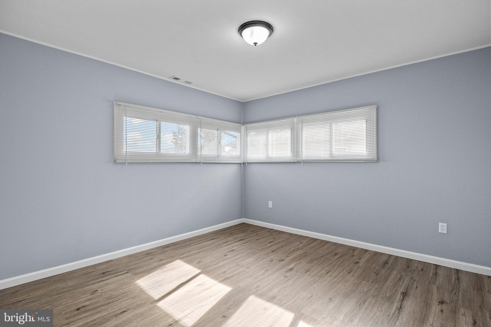 26 Oaktree Drive Levittown, PA 19055 - Photo 12 of 19 an empty room with wooden floor and windows