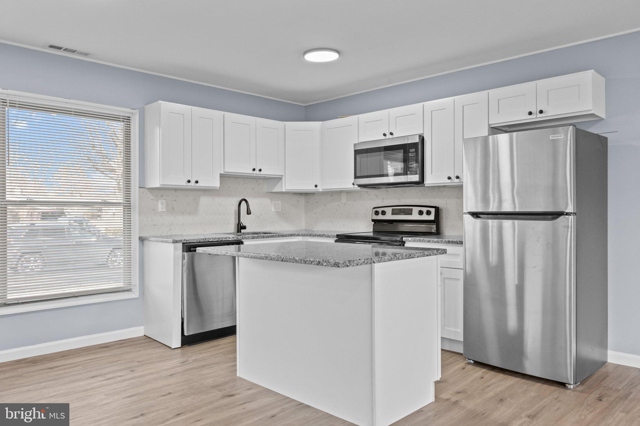 26 Oaktree Drive Levittown, PA 19055 - Photo 8 of 19 a kitchen with stainless steel appliances granite countertop a refrigerator stove a sink and a granite counter tops with wooden floors