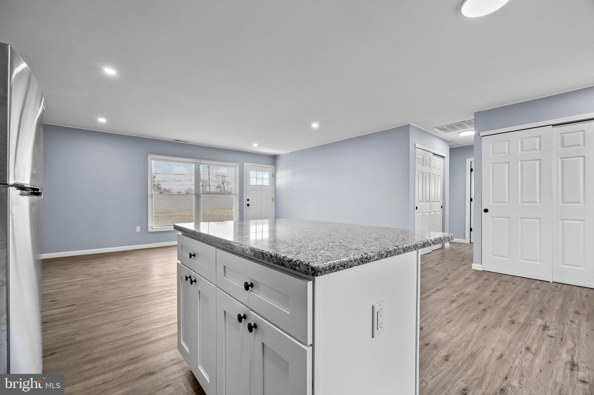 26 Oaktree Drive Levittown, PA 19055 - Photo 10 of 19 a hall with kitchen island white cabinets and wooden floor