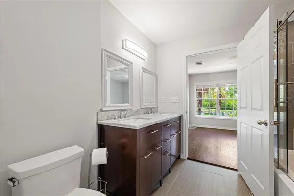 a bathroom with a granite countertop toilet a sink and a mirror