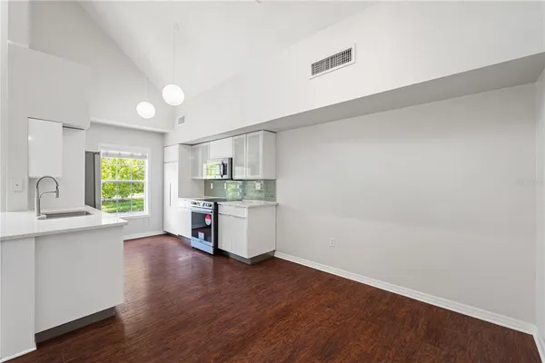 a room with stainless steel appliances wooden floor and a window