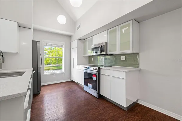 a kitchen with stainless steel appliances granite countertop a stove and a white cabinets