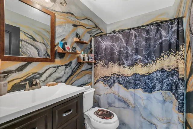 a bathroom with a sink a toilet and a mirror