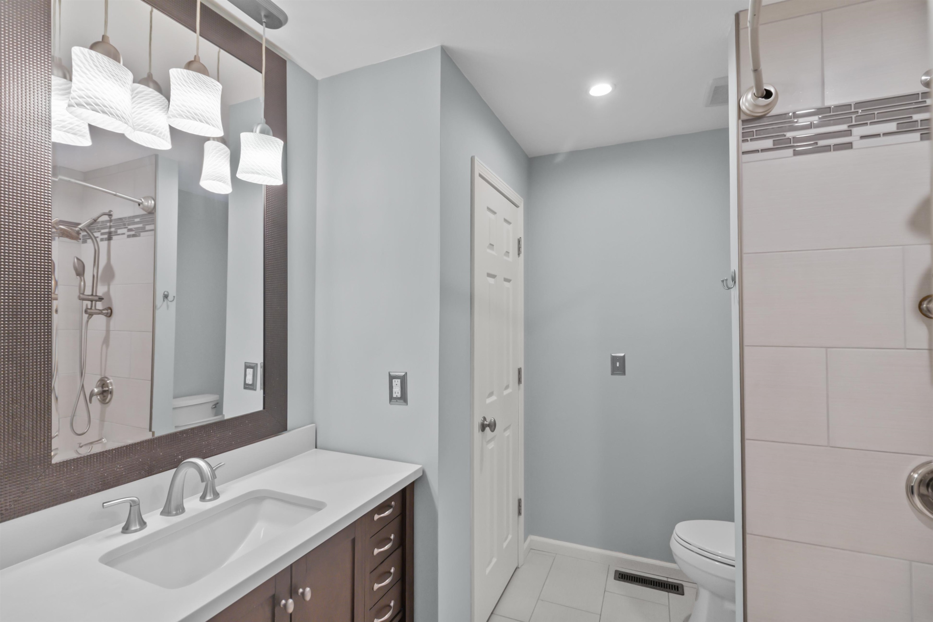 4657 High Point Drive, Unit 32 Rockford, IL 61114 - Photo 18 of 27 a bathroom with a sink a toilet and a large mirror