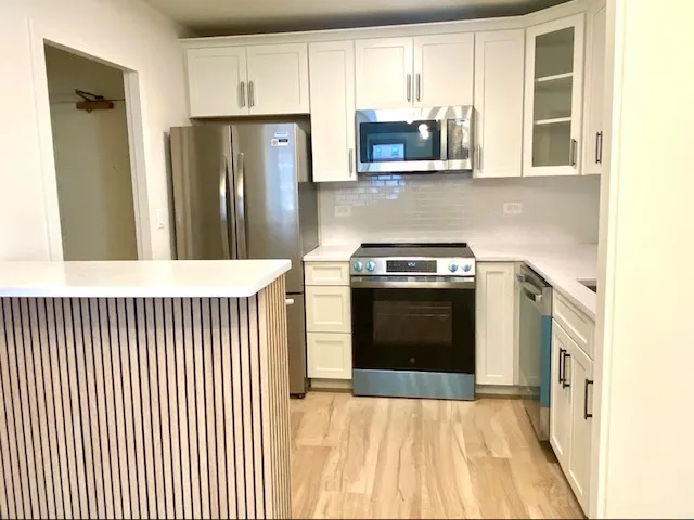 a kitchen with stainless steel appliances granite countertop a stove a refrigerator and a microwave