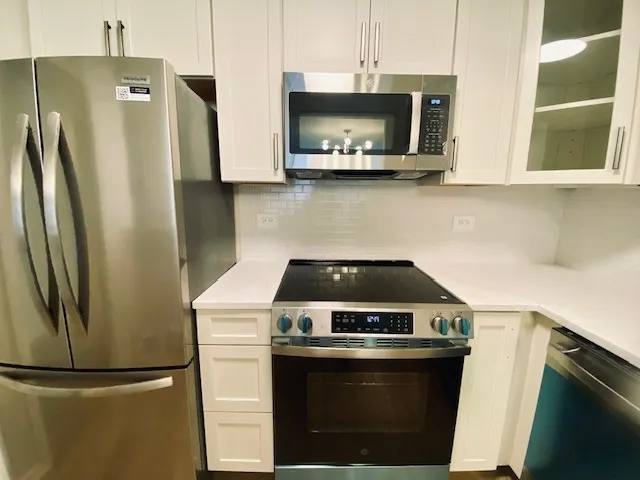 a kitchen with stainless steel appliances a stove a microwave and a refrigerator