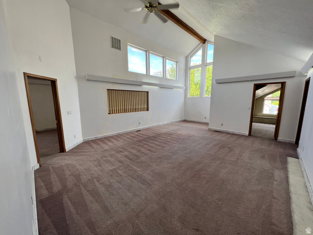3013 North 100 West Provo, UT 84604 - Photo 12 of 18 Unfurnished living room featuring high vaulted ceiling, beam ceiling, carpet floors, ceiling fan, and a textured ceiling