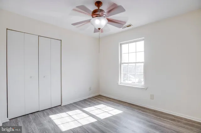 a view of an empty room and window chandelier fan