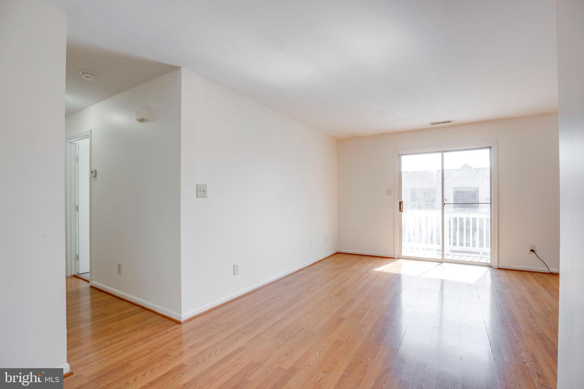 40 Smokewood Court, Unit 40200 Stafford, VA 22554 - Photo 5 of 26 an empty room with wooden floor and windows with curtains