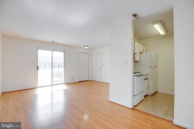 a view of a kitchen with wooden floor and electronic appliances