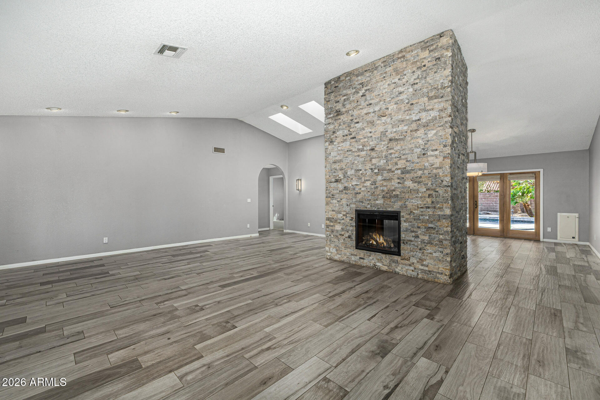 801 East Acoma Drive Phoenix, AZ 85022 - Photo 9 of 62 an empty room with wooden floor a fireplace and windows