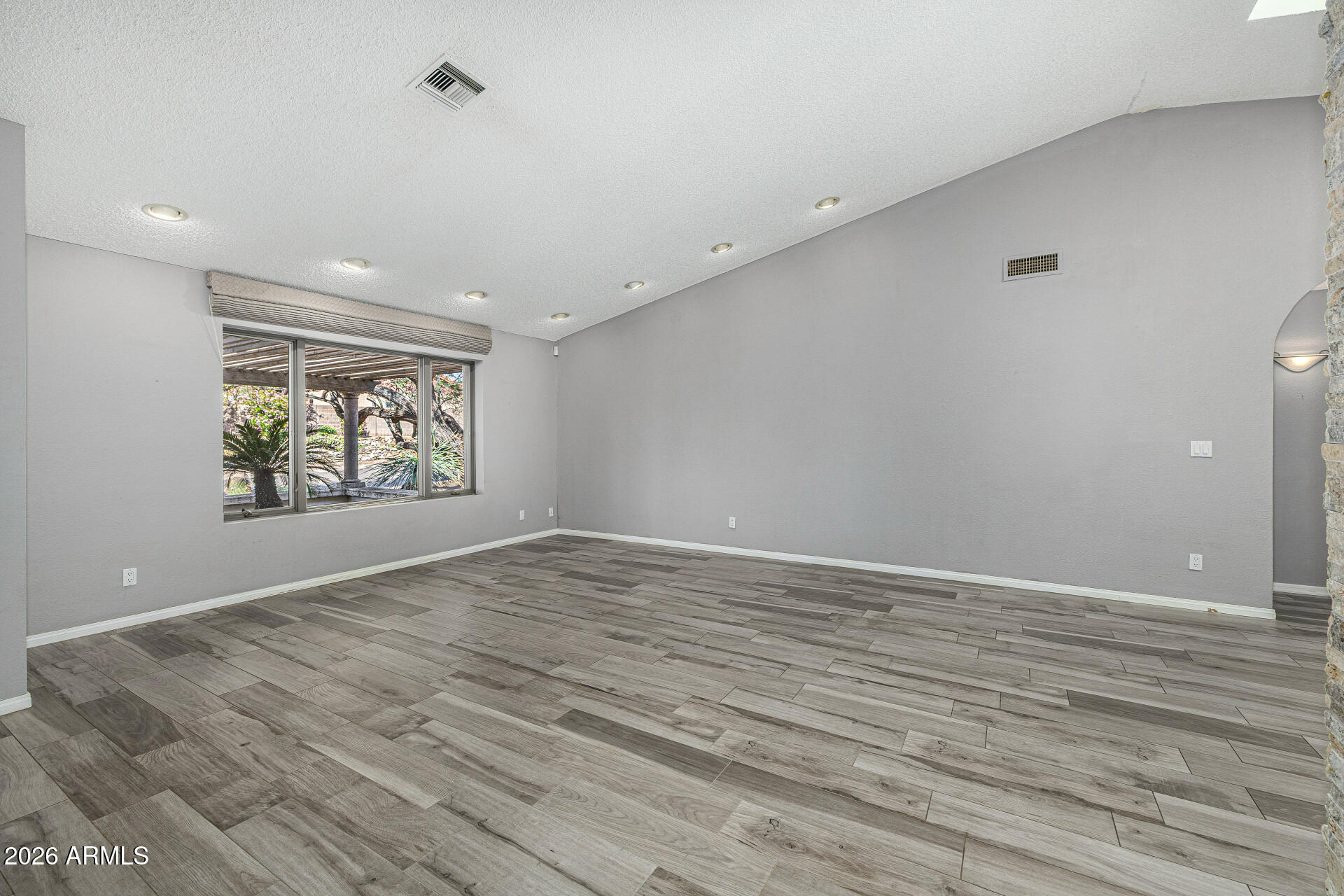 801 East Acoma Drive Phoenix, AZ 85022 - Photo 10 of 62 a view of an empty room with wooden floor and window