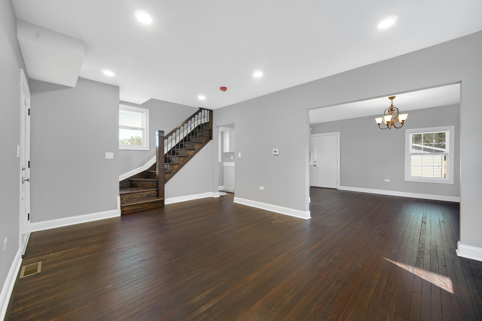 327 Buchanan Street Gary, IN 46402 - Photo 11 of 30 a view of an empty room with wooden floor and stairs