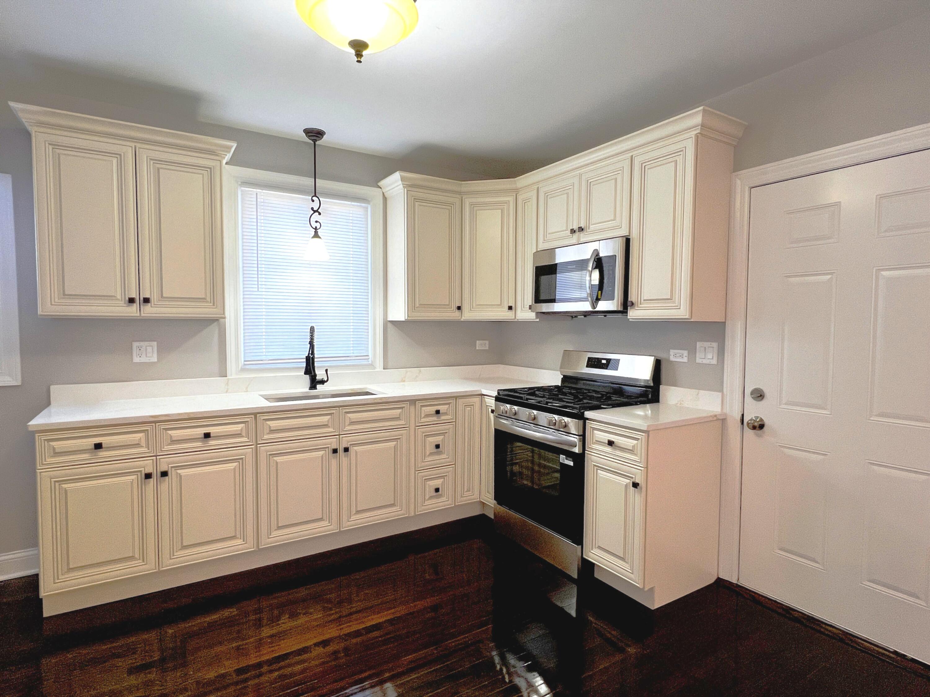 327 Buchanan Street Gary, IN 46402 - Photo 17 of 30 a kitchen with granite countertop white cabinets and stainless steel appliances