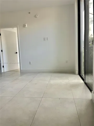 a view of a small space with wooden floor and a window