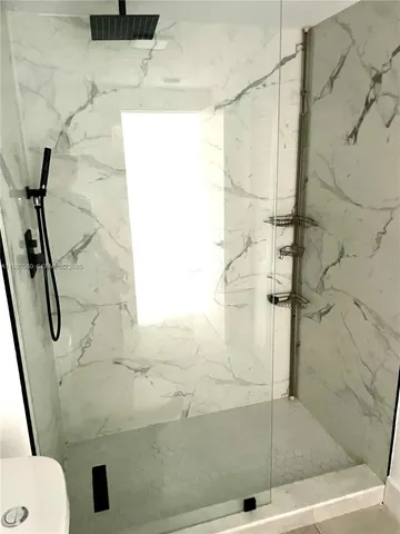 a view of an empty room with a fireplace and a window