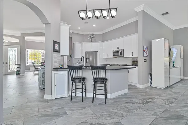 a kitchen with stainless steel appliances kitchen island granite countertop a refrigerator and microwave