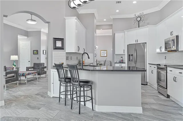 a kitchen with stainless steel appliances dining table and chairs