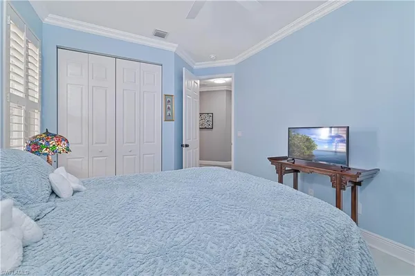 a bedroom with a bed table and a chair