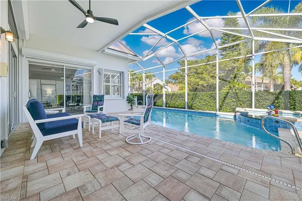 a living room with patio furniture and a floor to ceiling window