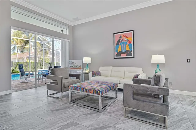 a living room with furniture a dining table and a chandelier