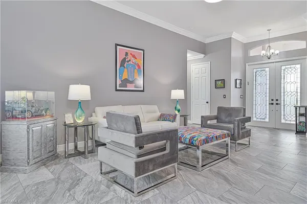 a living room with furniture a dining table and a chandelier