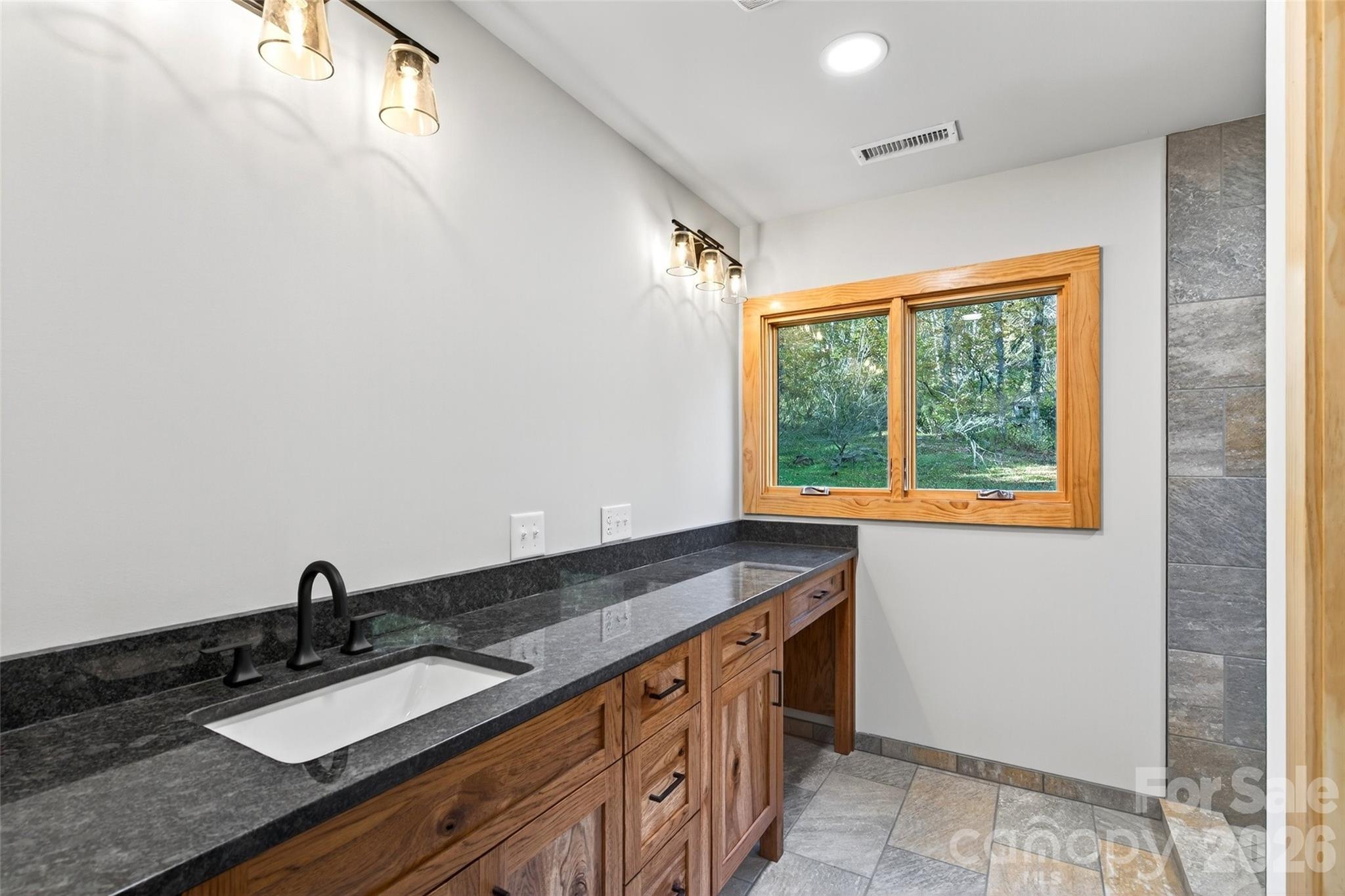 575 Croft Way Bakersville, NC 28705 - Photo 14 of 38 a bathroom with a granite countertop sink and a window