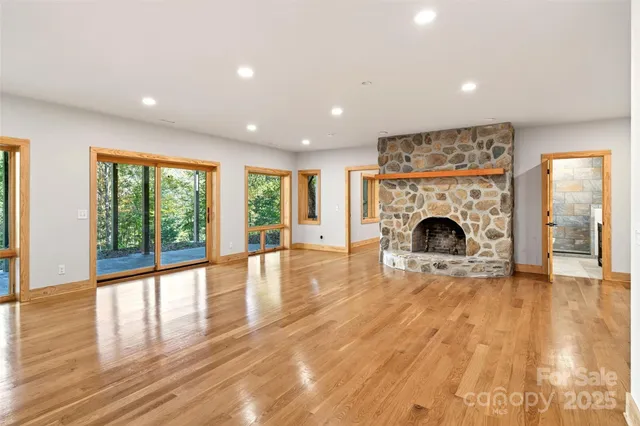 a view of empty room with wooden floor and fireplace