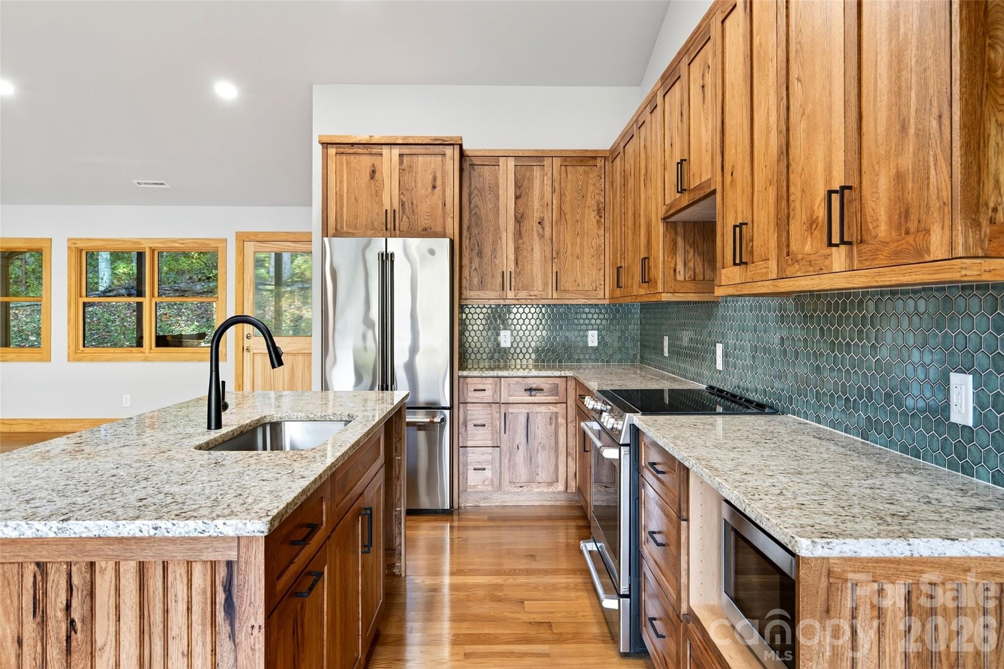 575 Croft Way Bakersville, NC 28705 - Photo 9 of 38 a kitchen with stainless steel appliances granite countertop a stove a sink and a microwave