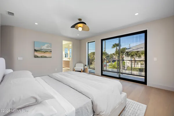 a spacious bedroom with a bed and glass door