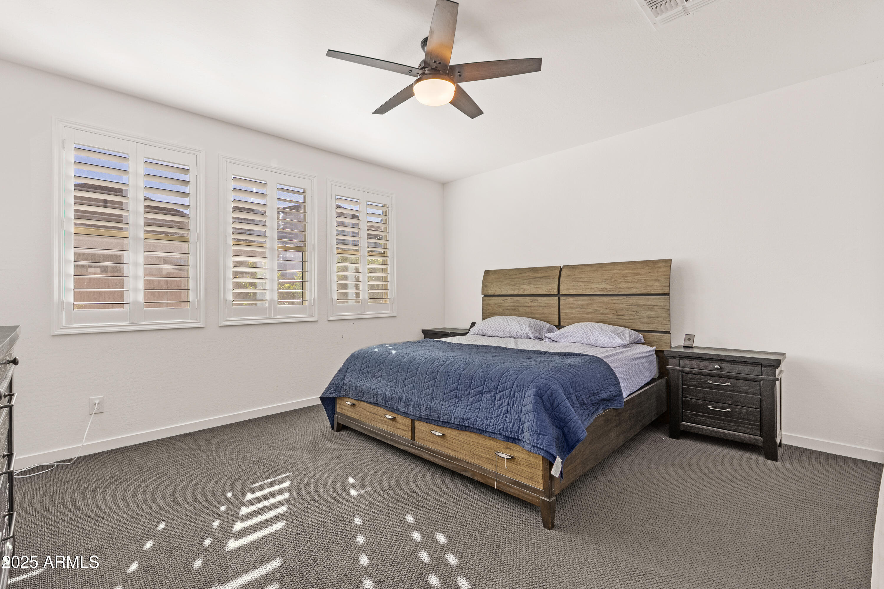 21357 East Macaw Drive Queen Creek, AZ 85142 - Photo 16 of 48 a spacious bedroom with a bed and a chandelier