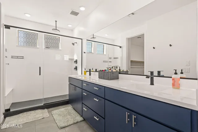 a bathroom with double vanity and a mirror