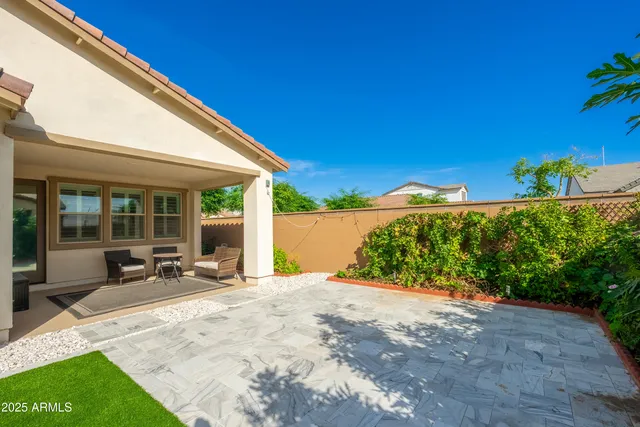 a view of a house with backyard and sitting area