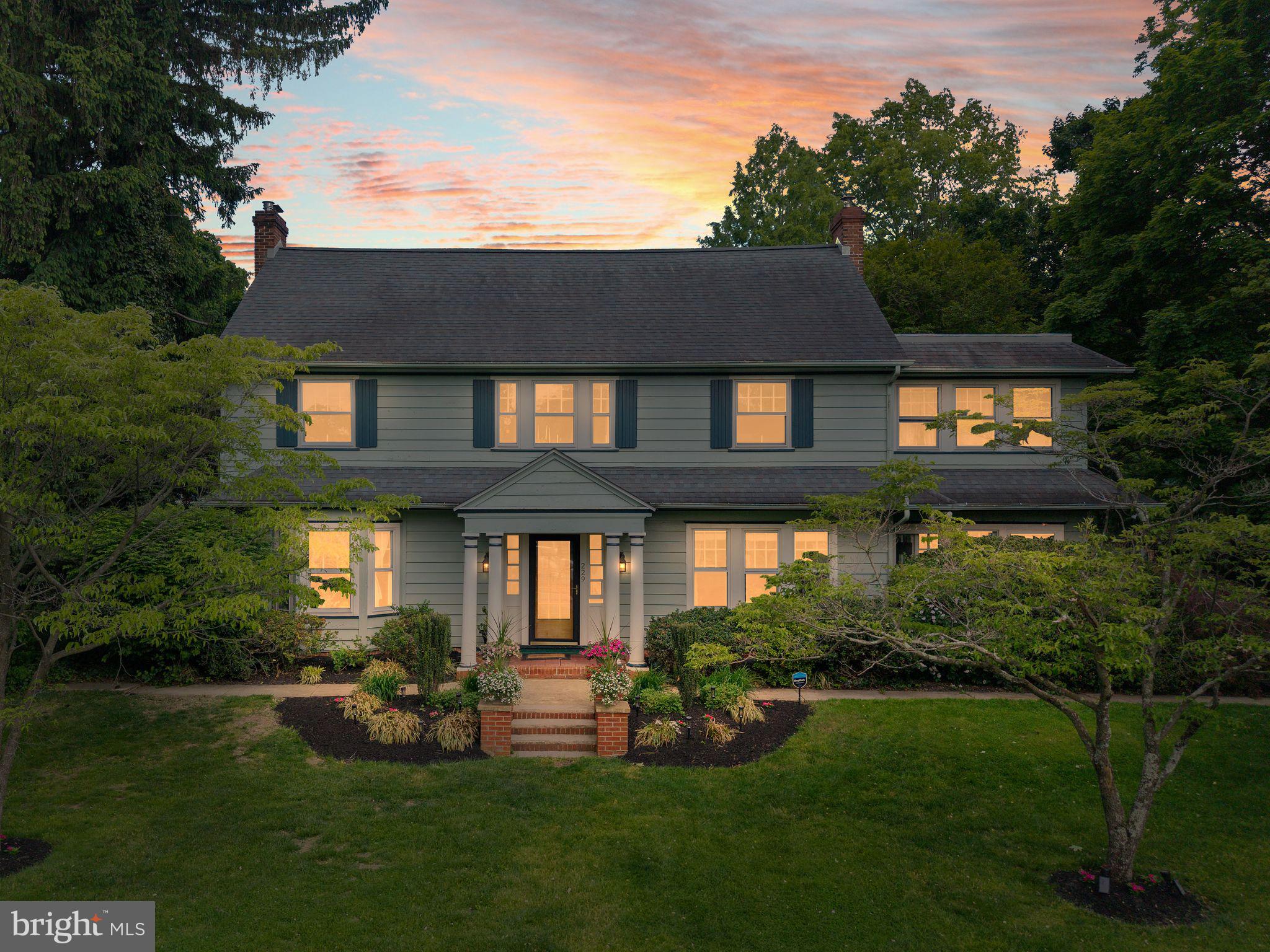 a front view of a house with a yard and green space