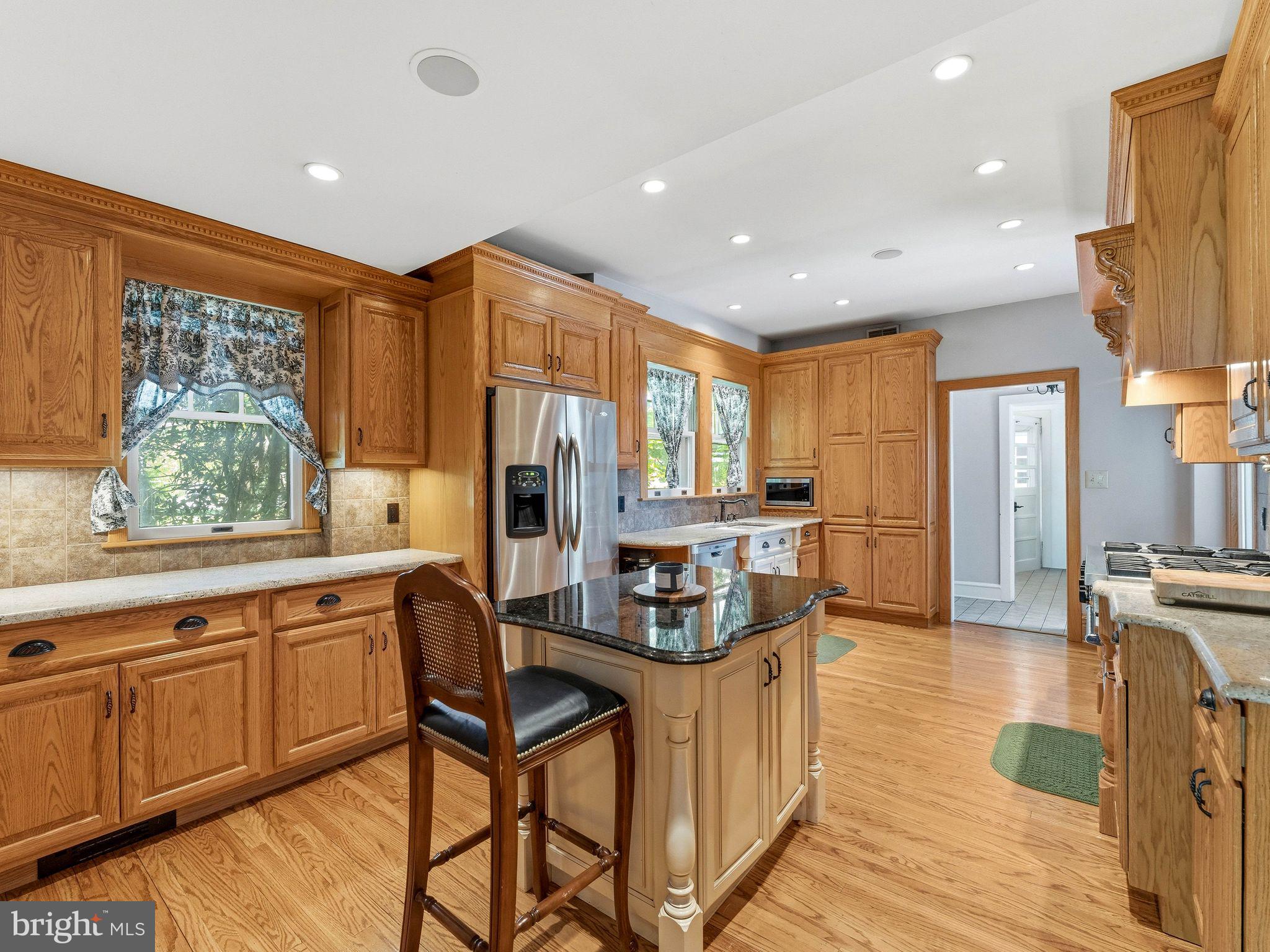 229 North Main Street Woodstown, NJ 08098 - Photo 23 of 74 a kitchen with stainless steel appliances granite countertop a refrigerator a sink dishwasher a stove and a dining table with wooden floor