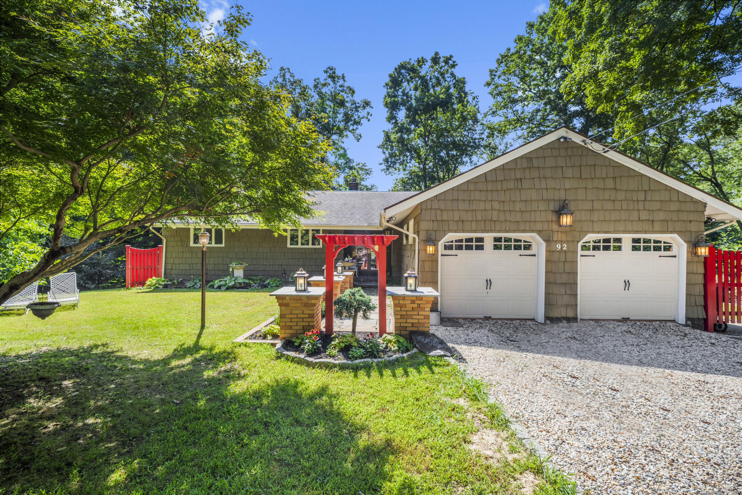 a view of a house with a small yard and a large tree