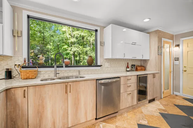 a kitchen with granite countertop a sink window and cabinets