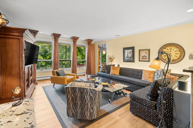 a living room with furniture fireplace and a large window