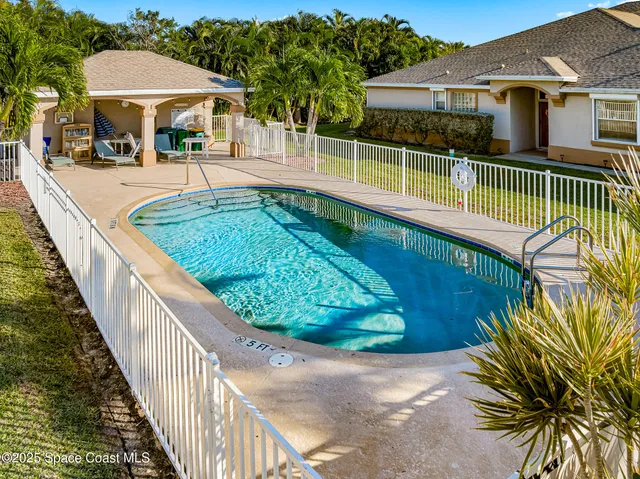 a view of a house with backyard and sitting area