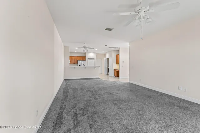 a view of empty room with a kitchen