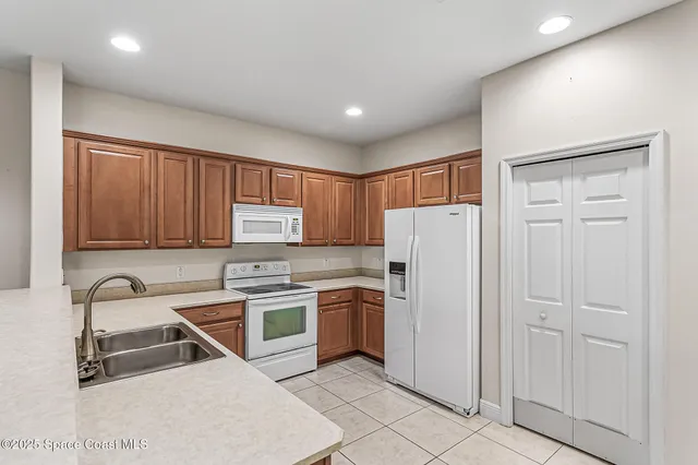 a kitchen with stainless steel appliances granite countertop a refrigerator and a stove top oven