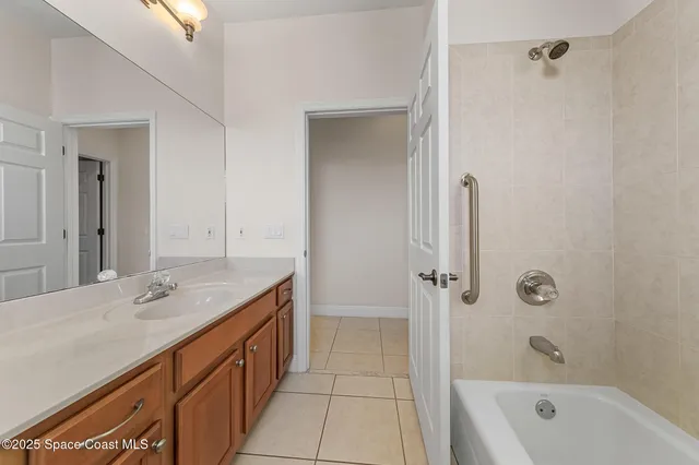 a bathroom with a granite countertop sink a mirror and a bathtub