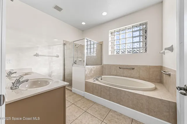 a spacious bathroom with a tub sink and mirror