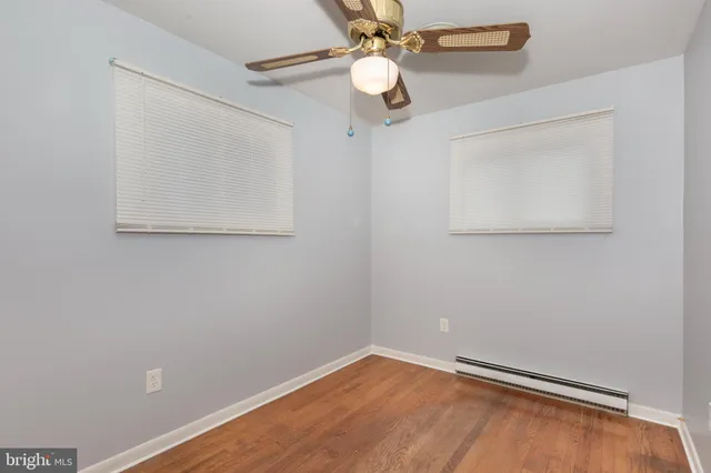 an empty room with a window and a fan