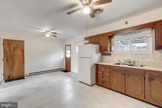 a view of kitchen with furniture and refrigerator