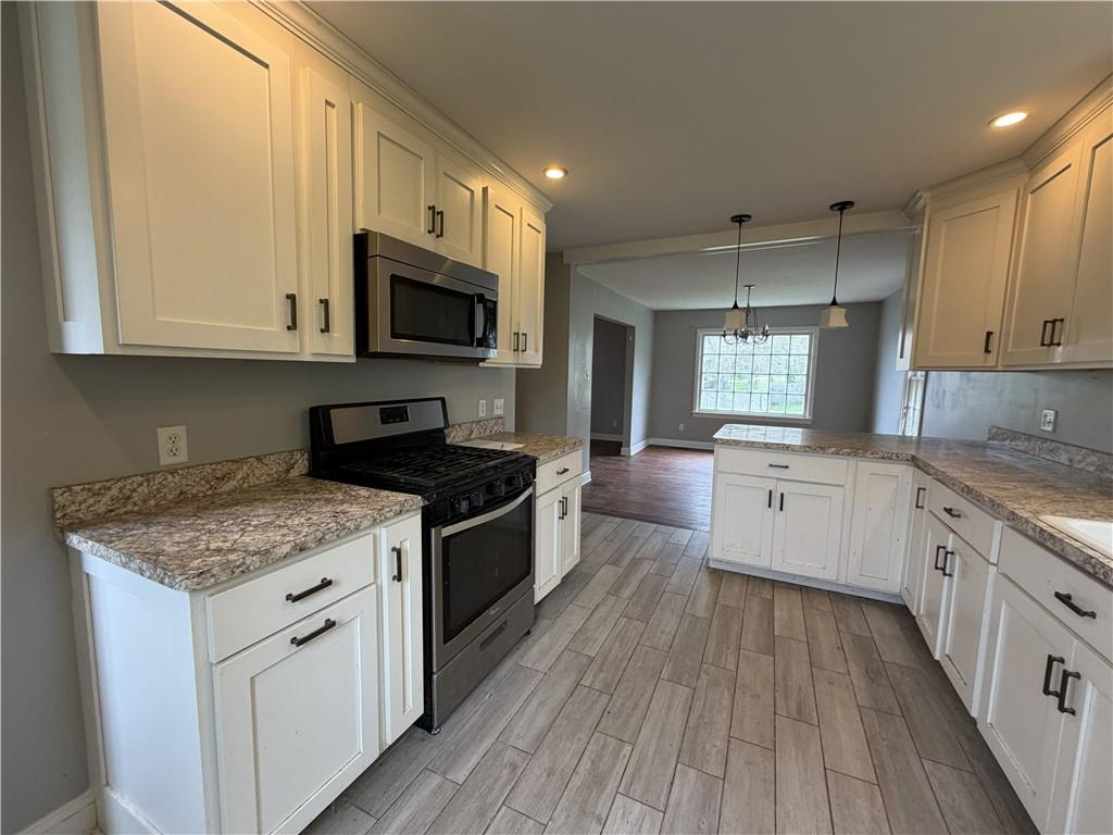 1146 Franklin Road Jackson Center, PA 16133 - Photo 8 of 19 a kitchen with stainless steel appliances granite countertop a stove a sink and a microwave