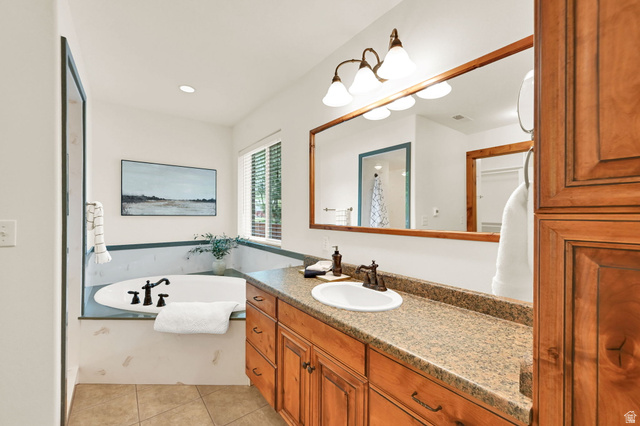 13658 South Fort Street Draper, UT 84020 - Photo 25 of 87 Bathroom featuring a built-in soaking tub with black fixtures, an expansive vanity with double sinks and stone-finish countertops, wood-finish cabinetry, and tiled flooring