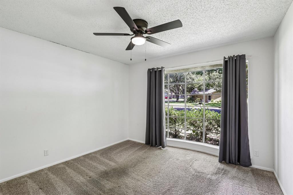 1600 South Timber Court Benbrook, TX 76126 - Photo 13 of 30 Room with neutral carpeting and white walls, featuring a curved bay window with street-facing exposure