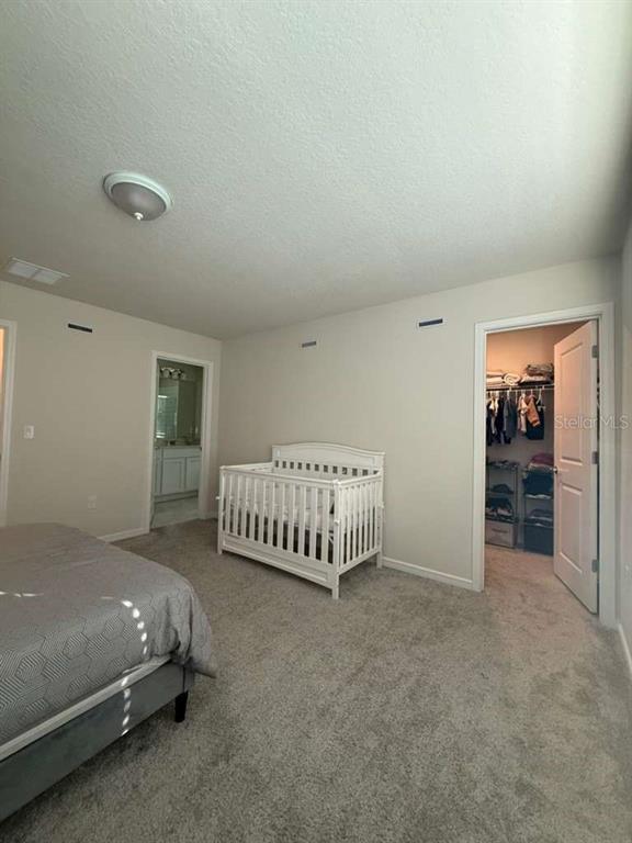 2579 Winsome Way Davenport, FL 33896 - Photo 16 of 25 a bedroom with a bed and a cabinets